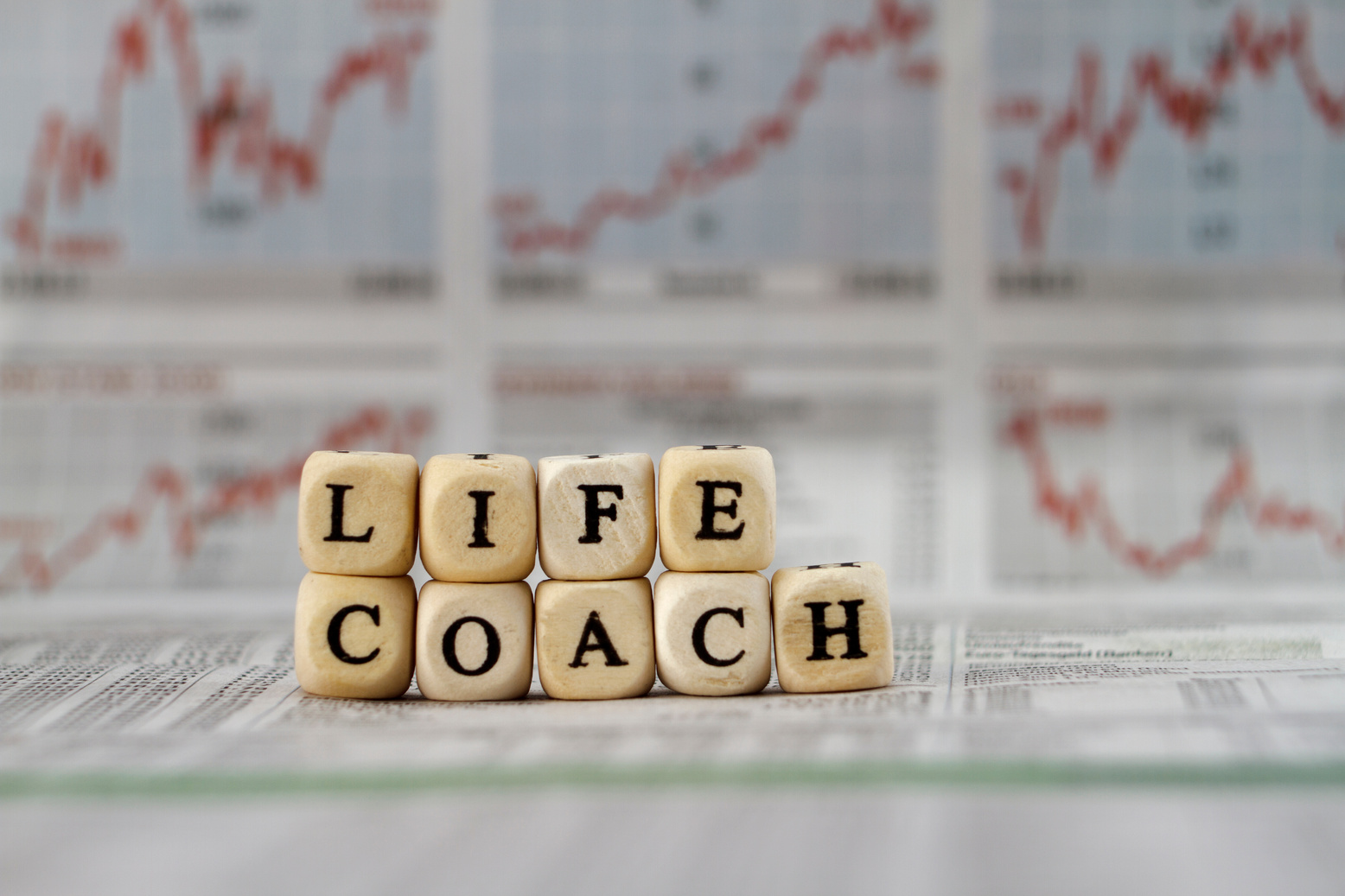 life coach built with letter cubes on newspaper background